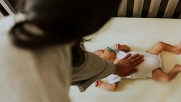 parent overlooking baby asleep in cot