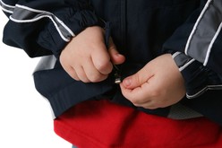 child fastening coat zip