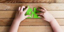 Child's hands piecing together a jigsaw
