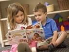 Boy and girl reading a book together