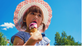Girl holding ice cream wearing summer hat