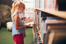 child looking at book in library