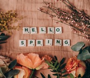 Hello Spring written with scrabble letters surrounded by flowers