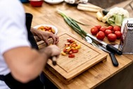 man chopping vegetables on a chopping board