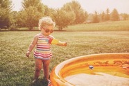 Gild stood next to paddling pool in sunglasses 