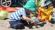 Child playing with sand on the beach