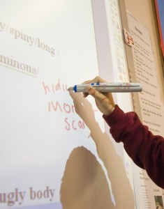 school child writing on a whiteboard