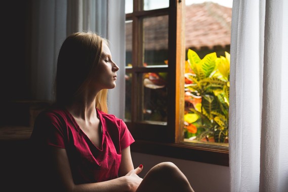 lady looking calm with her eyes closed by an open window