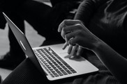 black and white photo of hands on a laptop