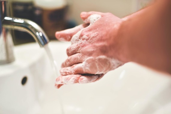 soapy hands under a tap