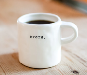 Mug filled with black coffee with the word 'begin' printed on it