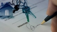 signing document, with house keys showing in corner