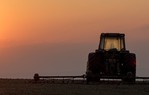 Tractor in field at sunset