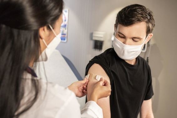 A nurse vaccinating a young man