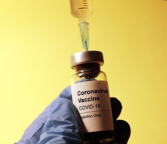 A vial with covid vaccine and a syringe. 