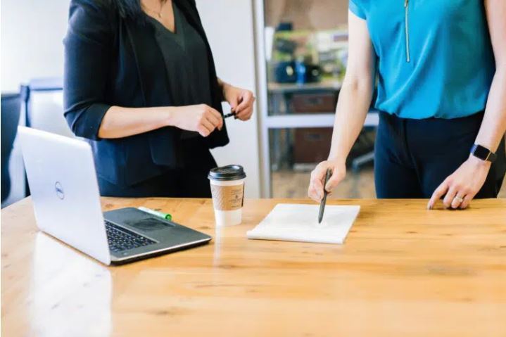 Two people standing by a table having a meeting
