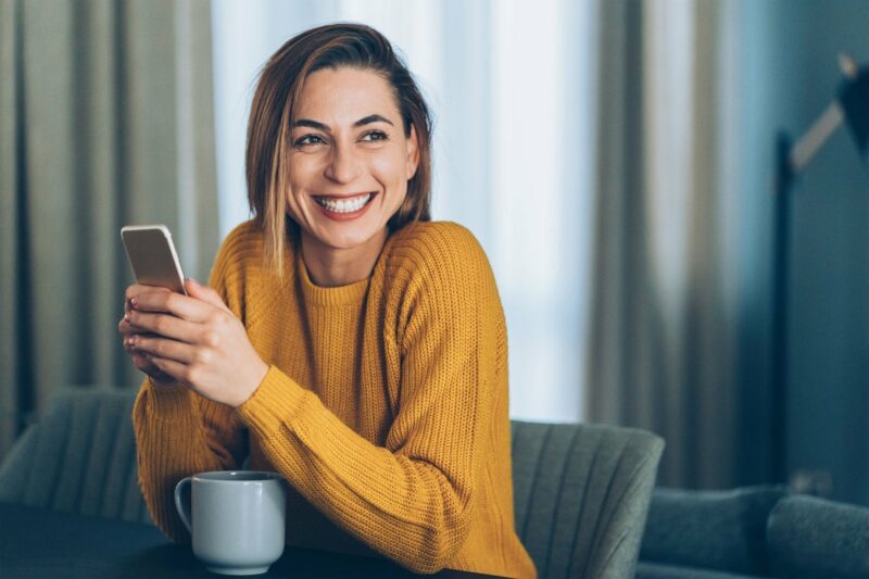 Woman holding a phone smiling
