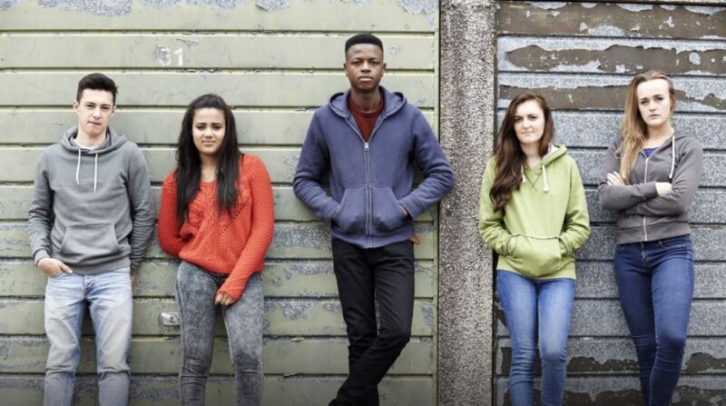 Teenagers leaning against a wall