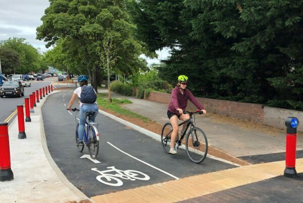 Two cyclists cycling along a cycle path.