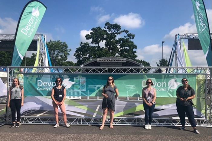 Five members of the Communications Team standing by the Devon County Show stand in the sun in 2021