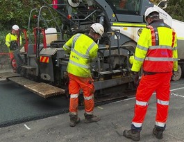 three men working with a resurfacing machine