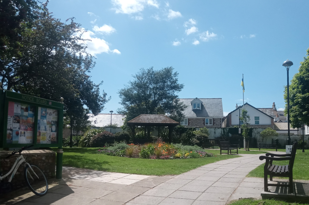 a town or village green with an old wooden shelter.