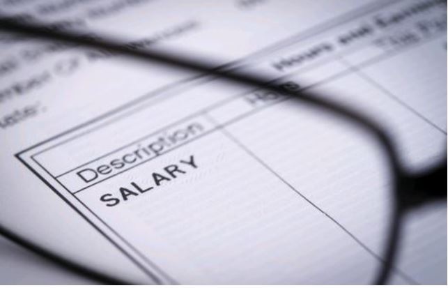 Pair of glasses looking at payslip