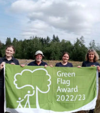 People hold up a Green Flag Award