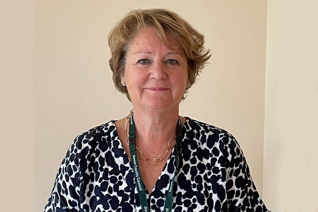 Jan Spicer - head and shoulders wearing a black and white top, against a wall indoors