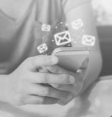 Greyscale image of hand holding a mobile phone and images of envelopes around
