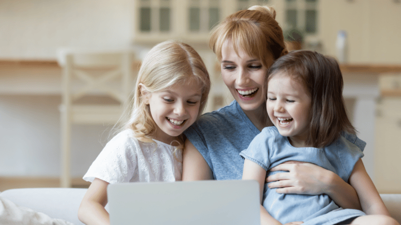 Mother with two small children looking at laptop