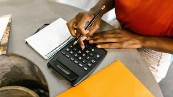 A person sat at a desk using a calculator