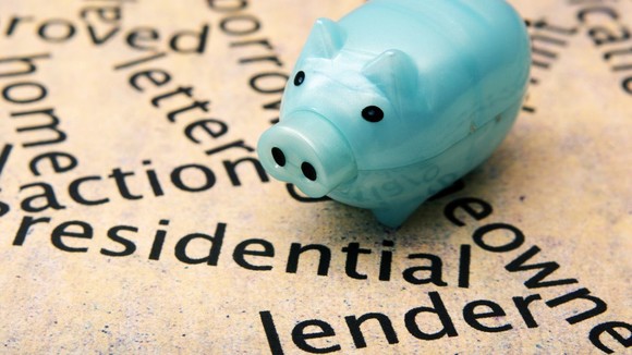 A piggy bank on a piece of paper on which it's written the word 'lender'