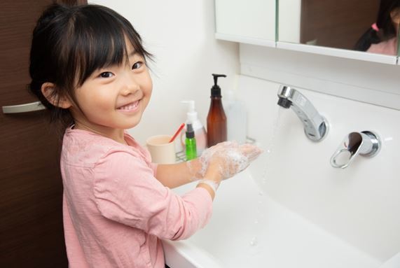 Girl washing her hands at the sink