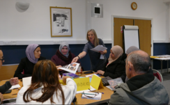 Volunteer teaching adult students in a classroom.