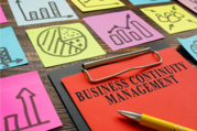 A clipboard showing  Business continuity management and drawings of graphs and charts surrounds it