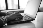 Black and white photo of person typing on laptop