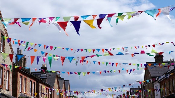 Lines of flags or bunting hung across a street, between houses, for a street party