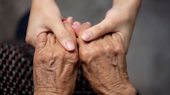 Hands holding an older persons hands