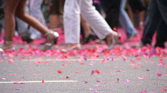 People walking in a street with confetti on the ground