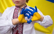 Boy with Ukrainian flag painted on his hand