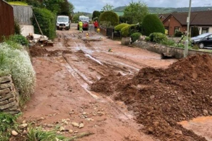 A road with mud and damage following a flash flood