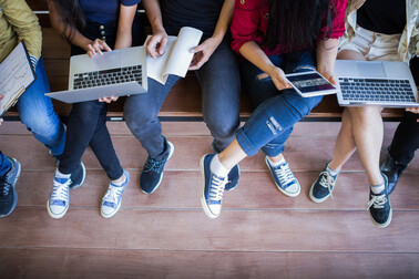 Photo of young people using laptops and mobile devices