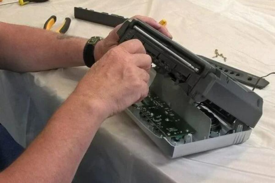 A close up photo of someone fixing a keyboard, with some tools.