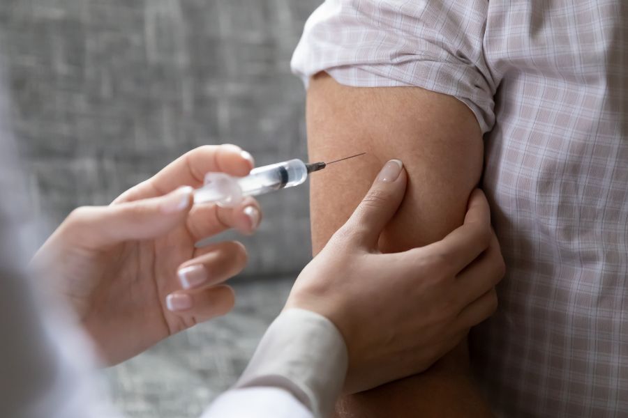 A person receiving their vaccination in their upper arm