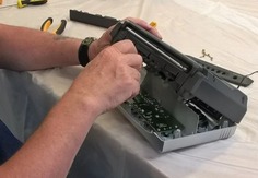 Hands repairing a piece of technology