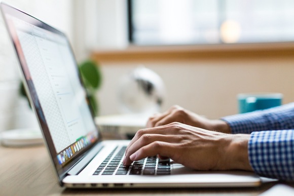 Man typing on laptop keyboard