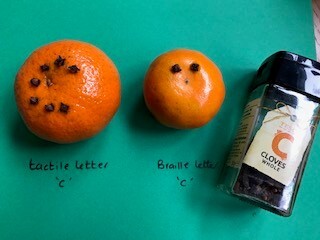 picture of an pomander for Christmas use a real orange with cloves for decoration