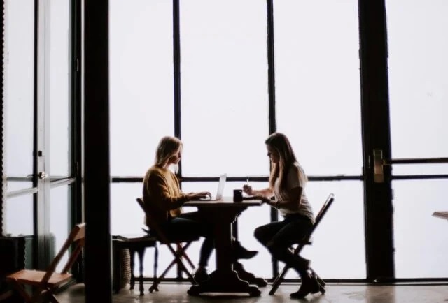 Two people sitting at a table having a discussion