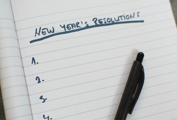 A note pad with the words 'New Year's Resolutions' at the top